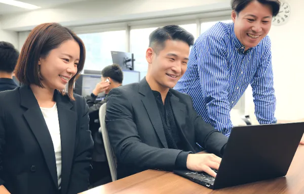 PC見ながら会話する社員３人
