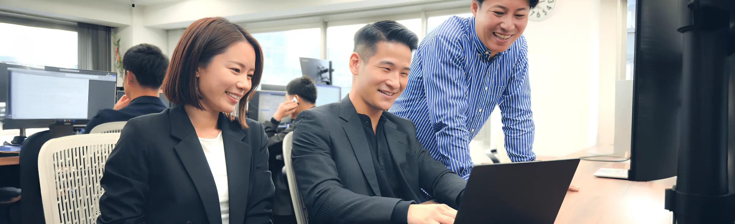 PC見ながら会話する社員３人